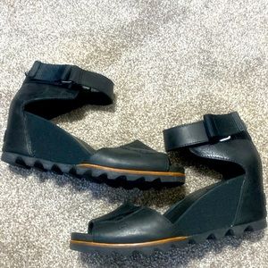 Sorel black leather peep-toe platform strap oh sandals with tan trim.